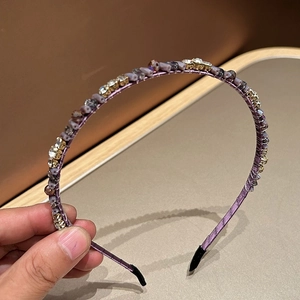 Detail of luxury rhinestone headband with purple silk wrap and crystal beads trim