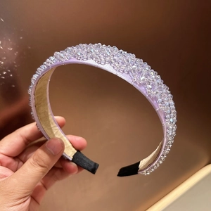 Close-up of a wide lavender headband with hand-woven crystals and soft fabric lining