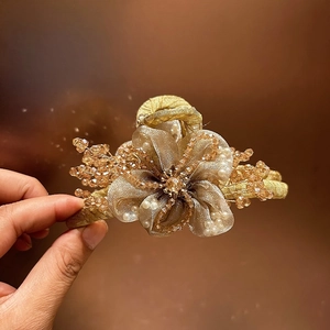 Dettaglio molletta capelli a fiore in organza champagne con cristalli e perle