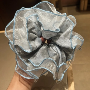 Detail of light blue organza and satin scrunchie with elegant hanging beads