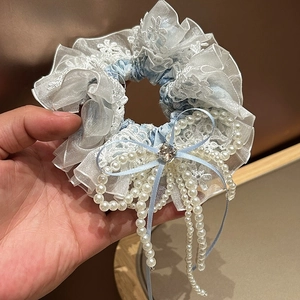 Détail de chouchou floral bleu clair avec dentelle bulle et nœud en perles cristal