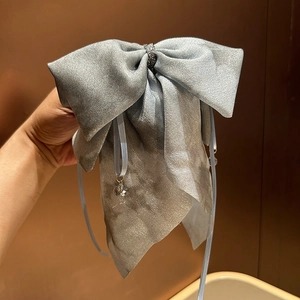 Detail of silver blue silk bow hair clip with crystal pendant and sparkling rhinestones