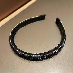 Close-up of black beaded headband with golden chain detail and faceted obsidian-style beads