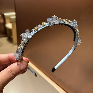 Détail d'un serre-tête en satin bleu clair avec fleurs en cristal et dents antidérapantes