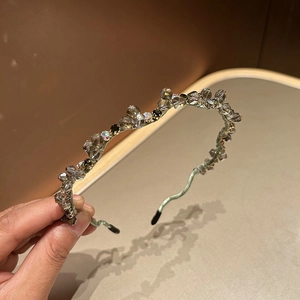 Detail of handcrafted green crystal beaded headband with shimmering gemstones and metal frame