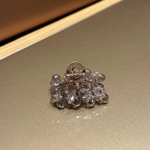 Close-up of elegant small hair claw clip with sparkling crystals and golden spring mechanism