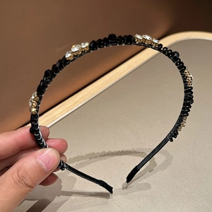 Detailed macro view of minimalist black headband with sparkling rhinestones and mineral beads