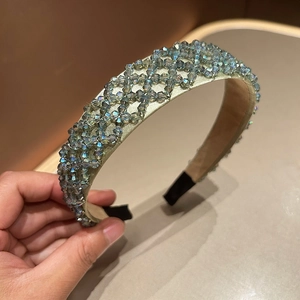 Detail of handcrafted grey crystal beaded headband with intricate woven patterns on satin base