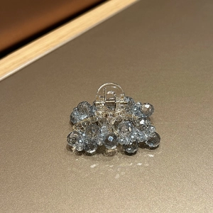 Detailed view of luxury crystal hair claw clip with blue-grey faceted beads and clear base