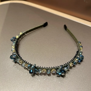 Détail des dents de peigne antidérapantes et perles de cristal bleu sur le serre-tête olive