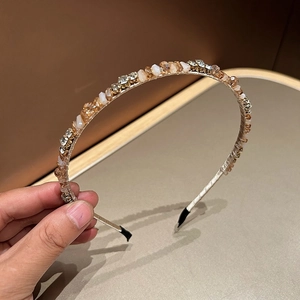 Macro shot of handcrafted luxury headband with champagne beads and sparkling rhinestones