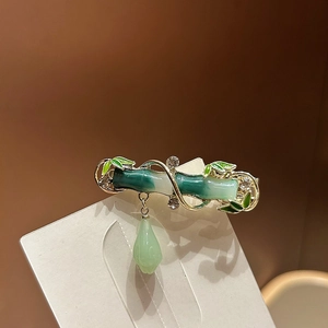 Detail of bamboo shaped hair clip with green gradient finish and pearl tassel
