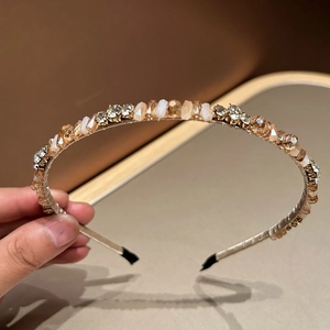 Detail shot of champagne gold rhinestone headband with hand-beaded crystal embellishments