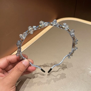 Detail of light blue silk headband with shimmering crystal beads held in hand