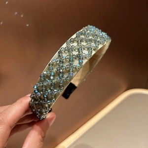 Close-up of handmade crystal beaded headband with iridescent purple and gold woven details