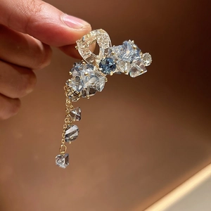 Detail einer Haarklammer mit blauen Kristallen, elegantem Quastenanhänger und sicherem Halt