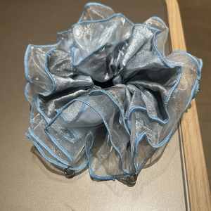 Detailed view of large silver satin and light blue organza scrunchie with bead trim