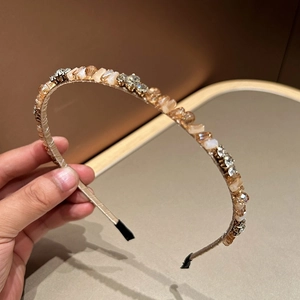 Macro detail of luxury gold headband featuring champagne crystals and diamond rhinestones