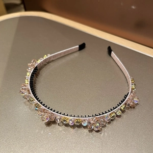 Détail d'un serre-tête en cristal avec perles roses et jaunes et dents antidérapantes