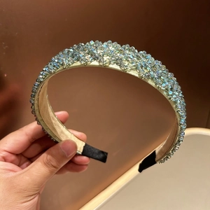 Detailed view of light blue crystal beads hand-woven on a golden satin headband