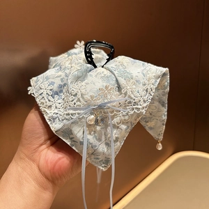 Détail de la pince à cheveux à fleurs bleues avec dentelle blanche et glands de perles