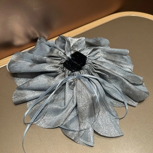 Detailed macro view of an oversized silver-grey fabric flower hair clip with crystal bead