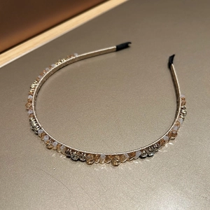 Detailed view of champagne gold headband with sparkling crystals and beads decoration