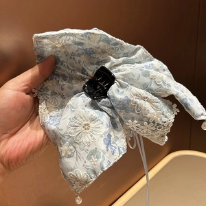 Détail de la pince à cheveux en seersucker bleu clair avec broderie et perles