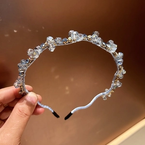 Close-up of light blue crystal beaded headband with intricate hand-woven wire design