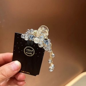 Detail of crystal mini hair claw clip with tassels and sparkling blue rhinestones