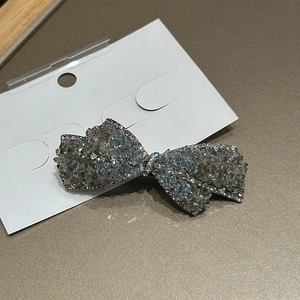 Gros plan d'une barrette à cheveux en forme de nœud ornée de cristaux et de strass argentés