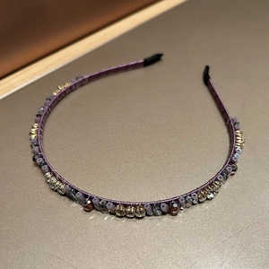 Detail view of purple fabric headband with sparkling faceted crystals and colorful beads