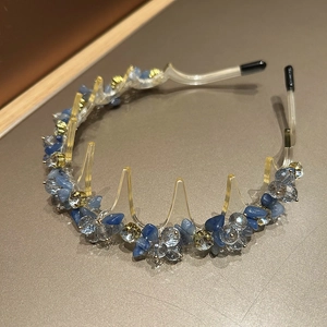 Close-up of wavy crystal headband with blue stones and clear zircon in gold claws