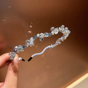 Detailed view of the wavy crystal headband with sparkling blue and clear rhinestones
