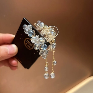 Detail of light blue crystal flower hair claw with elegant dangling fringe tassels