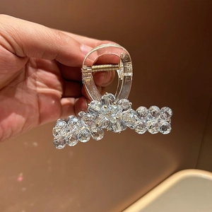 Macro shot of a clear claw clip with sparkling crystal bead flower design and metal spring