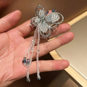 Elegant silver butterfly hair clip with blue and white crystals and beaded tassels