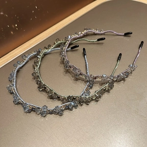 Detailed macro view of three crystal-studded headbands in blue, green, and purple