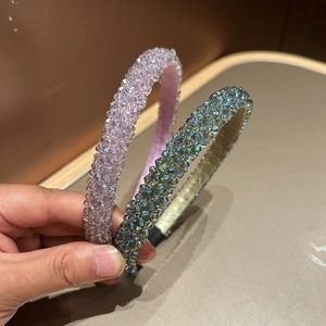 Close-up of handmade crystal beaded headbands in lilac and turquoise green finishes