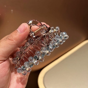 Pince à cheveux en acrylique marron avec perles facettées pour cheveux épais sur fond chaud