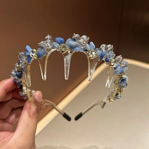 Close-up of sparkling blue crystals and golden rhinestones on a luxury crystal headband