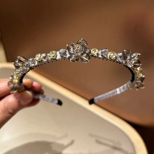 Gros plan d'un serre-tête de luxe avec tissu gris et strass en forme de fleurs jaunes