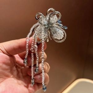 Detail of silver alloy butterfly hair claw with blue beaded tassels and crystal accents