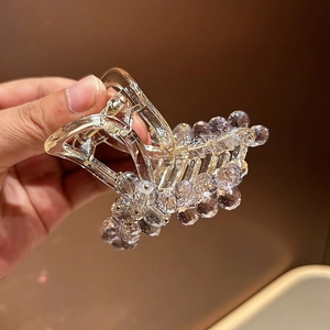 Detailed macro view of clear rhinestones and strong metal spring on luxury hair claw clip