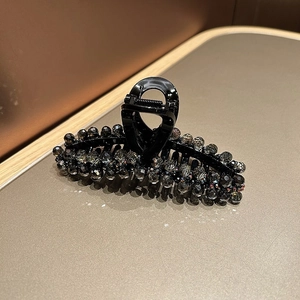 Detail of large black hair claw clip with reflective faceted crystal bead decorations