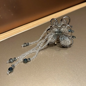 Close-up of butterfly hair claw clip with blue crystal beads and hanging tassels