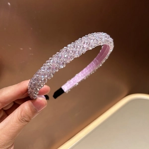 Close-up of handmade crystal beaded headband with purple sparkling stones and silk base