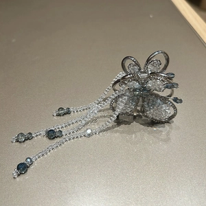 Detail of flower hair claw with crystal petals and long blue beaded tassels accessory