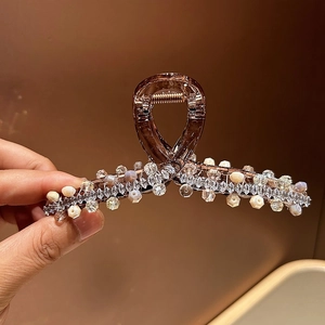 Detail of shark hair claw clip with brown resin, crystal beads and zircon embellishments