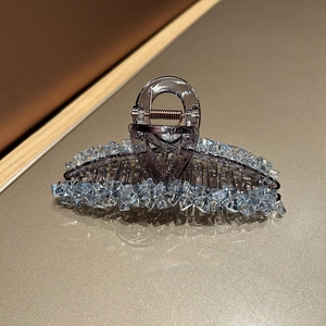 Detailed view of grey acrylic hair claw clip with light blue crystals and metal spring